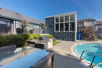 A pool with a hot tub and a house with a swimming pool